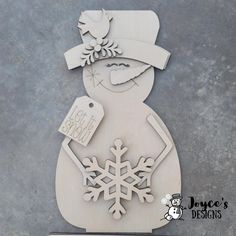 a snowman with a hat, scarf and mittens is cut out of wood