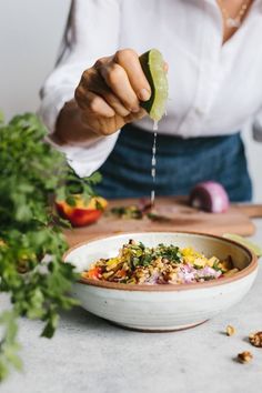 a woman is preparing food in a bowl