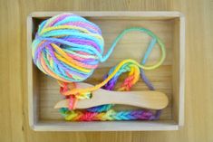 a wooden box with yarn and a crochet hook