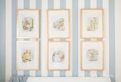 four framed pictures hang on the wall above a crib