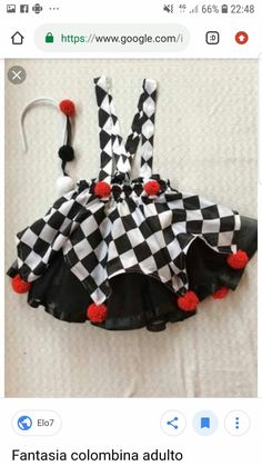 a black and white checkered dress with red pom poms on the bottom