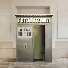 an atm machine sitting on the side of a building next to a door that says automat