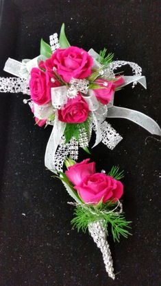 three pink roses are tied together with white ribbons