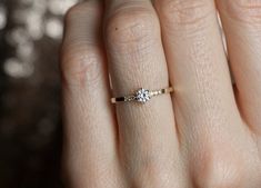 a woman's hand with a diamond ring on it