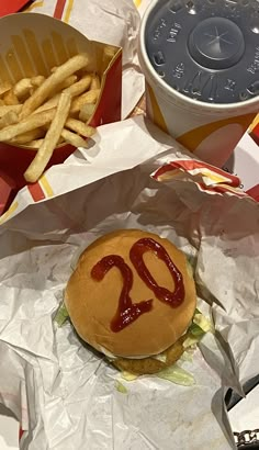 a hamburger with ketchup and french fries on it sitting on top of a table