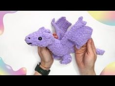 a person holding a purple stuffed animal in their left hand and the other hand is pointing at it