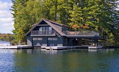 a house sitting on top of a lake surrounded by trees