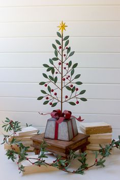 a small christmas tree sitting on top of a pile of books