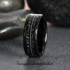 a wedding band with black and white diamonds inlayed to the inside of it