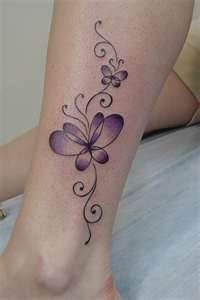 a woman's leg with a tattoo on it that has purple flowers and swirls