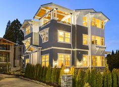 a two story house lit up at night with lights on the front and side windows