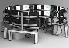 an office cubicle with multiple computer screens on it