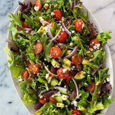 a salad with tomatoes, cucumbers, onions and feta cheese on it