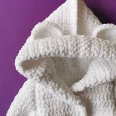 a white knitted coat on a purple background