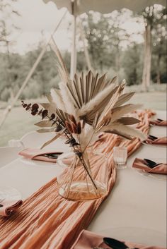 a table set up with napkins and flowers in a vase on top of it