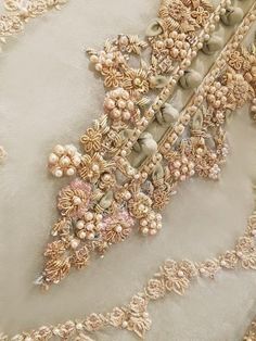 an embroidered fabric with pearls and beads on it