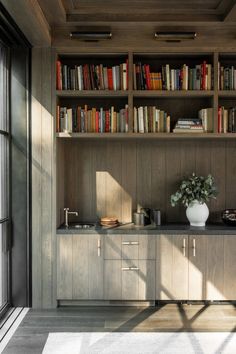 a bookshelf filled with lots of books next to a window