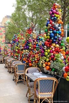 there are many tables and chairs with colorful balls on them