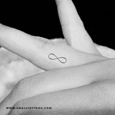 a woman's hand with an infinite symbol tattoo on it