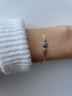 Brush away negative energy and stay protected with this dainty evil eye bracelet! D E T A I L S *It features a gold filled evil eye charm (12 x 6.5mm) in traditional blue *on a high quality 18k gold filled Figaro chain in yellow gold. *Gold filled is a wonderful alternative to solid gold and unlike gold plating does not rub off. *A tiny gold filled cross dangles from the chain. *It closes with a gold filled lobster clasp. *Choose the length from the drop down menu. Use the length guide as a reference to help you get the right size. Bracelet needs to be snug to stop it rolling. C A R E * T I P :  To keep your bracelet in great condition avoid contact with water, perfume and chemicals. Also remove when exercising and sleeping . P A C K A G I N G: All our products are gift ready. T E R M S* O Gold Spiritual Evil Eye Bracelet For Everyday, Dainty Yellow Gold Bracelet With Evil Eye Detail, Dainty Yellow Gold Bracelet With Evil Eye, Dainty Evil Eye Bracelet With Adjustable Chain, Dainty Gold Evil Eye Bracelet With Adjustable Chain, Dainty Gold Bracelets With Evil Eye, Gold Spiritual Evil Eye Bracelet With Adjustable Chain, Dainty Gold Evil Eye Bracelet, Gold Evil Eye Bracelets