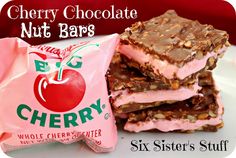 three bars are stacked on top of each other with chocolate and cherries in the background