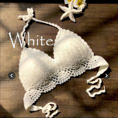 a white bra on a wooden table next to a starfish and flower with the word love spelled out