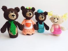 four crocheted teddy bears standing next to each other in front of a white background