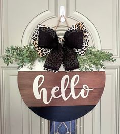 a door hanger that says hello on it with a bow hanging from the front