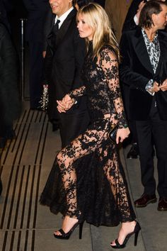 two people in formal wear walking down the street