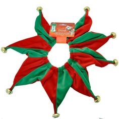 a red and green christmas star with bells on it's head, sitting in front of a white background