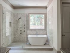 a bath tub sitting under a window in a bathroom