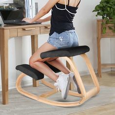 a woman sitting on a chair using a laptop computer