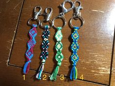 four different colors of bracelets on a wooden table next to a pair of scissors