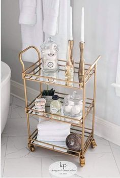 a gold bathroom shelf with candles, towels and other items