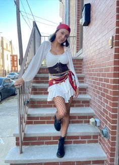 a woman in a pirate costume is walking down the stairs with her hands on her hips