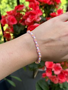 Glass bead bracelet with pink petals, yellow centers, and pearl beads. Purple Petals, Pearl Beaded Bracelet, Glass Bead Bracelet, Pink Petals, Lilac Flowers, Glass Beaded Bracelets, Pink Flower, Bead Bracelet, Glass Bead