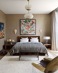 a bedroom with a large bed and paintings on the wall