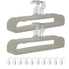 four white plastic hangers with clips on them and six white plastic hooks in the middle