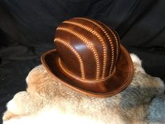 "Leather Steampunk Bowler Hat Made with Crazy Cow (Coach) Leather. This leather has some Amazing markings making each item a real one off. There is no way there will be another like this one, even if you use the same colour leather. Head Size is 60\" I can Make these to order if you need another size or colour then please do get in touch. Materials Used: 1.8mm-2mm Leather Wax Thread Curved Metal Wire Hat length - 33cm Hat Width - 28cm Hat height - 16cm All Hand Stitched. Please message us with any questions! Happy Shopping! Less" Steampunk Leather Hat Band With Short Brim, Steampunk Leather Brimmed Hat Bands, Steampunk Leather Hat For Festivals, Steampunk Leather Festival Hat, Vintage Leather Hat With High Crown, Vintage High Crown Leather Hat, Vintage Leather High Crown Hat, Festival Leather Hat Bands In Brown, Brown Leather Hats For Festivals