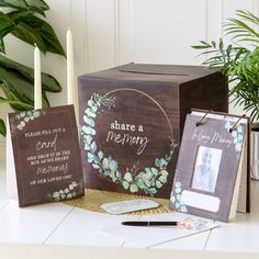 three wooden boxes with cards and candles on a table next to a potted plant