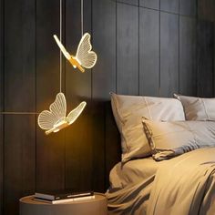 a bed room with a neatly made bed and two lights hanging from the ceiling above it