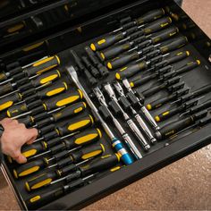 a man is holding a tool set in his hand and it's inside the case