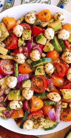 a white bowl filled with lots of different types of vegetables