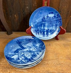 three blue and white plates sitting on top of a wooden table next to each other