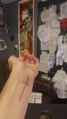 a person's arm with a tattoo on it and a cross in the middle