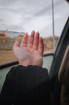 a person's hand sticking out the window of a car