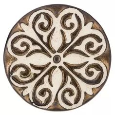 a white and brown decorative button with swirls on the center, in an ornate design