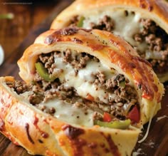 some meat and cheese stuffed bread rolls on a cutting board