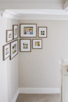 a wall with many pictures hanging on it's side, and a baby crib in the corner