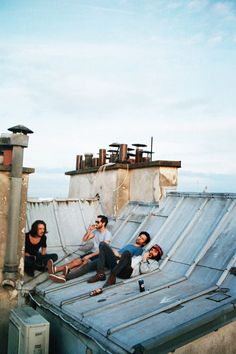 some people are sitting on the roof of an old building